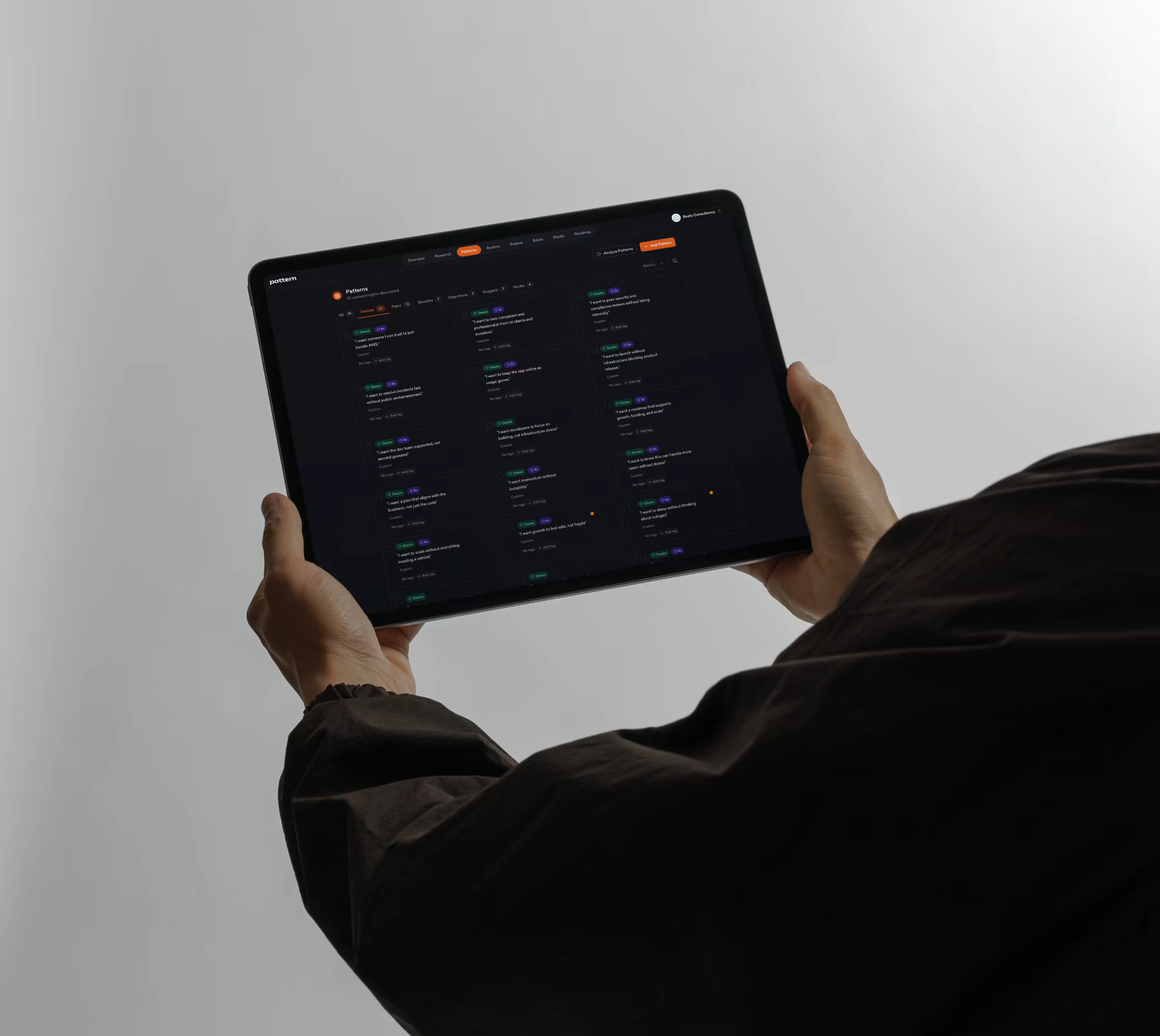 Pattern's Patterns Library held on an iPad — customer-language patterns sourced and confidence-scored.