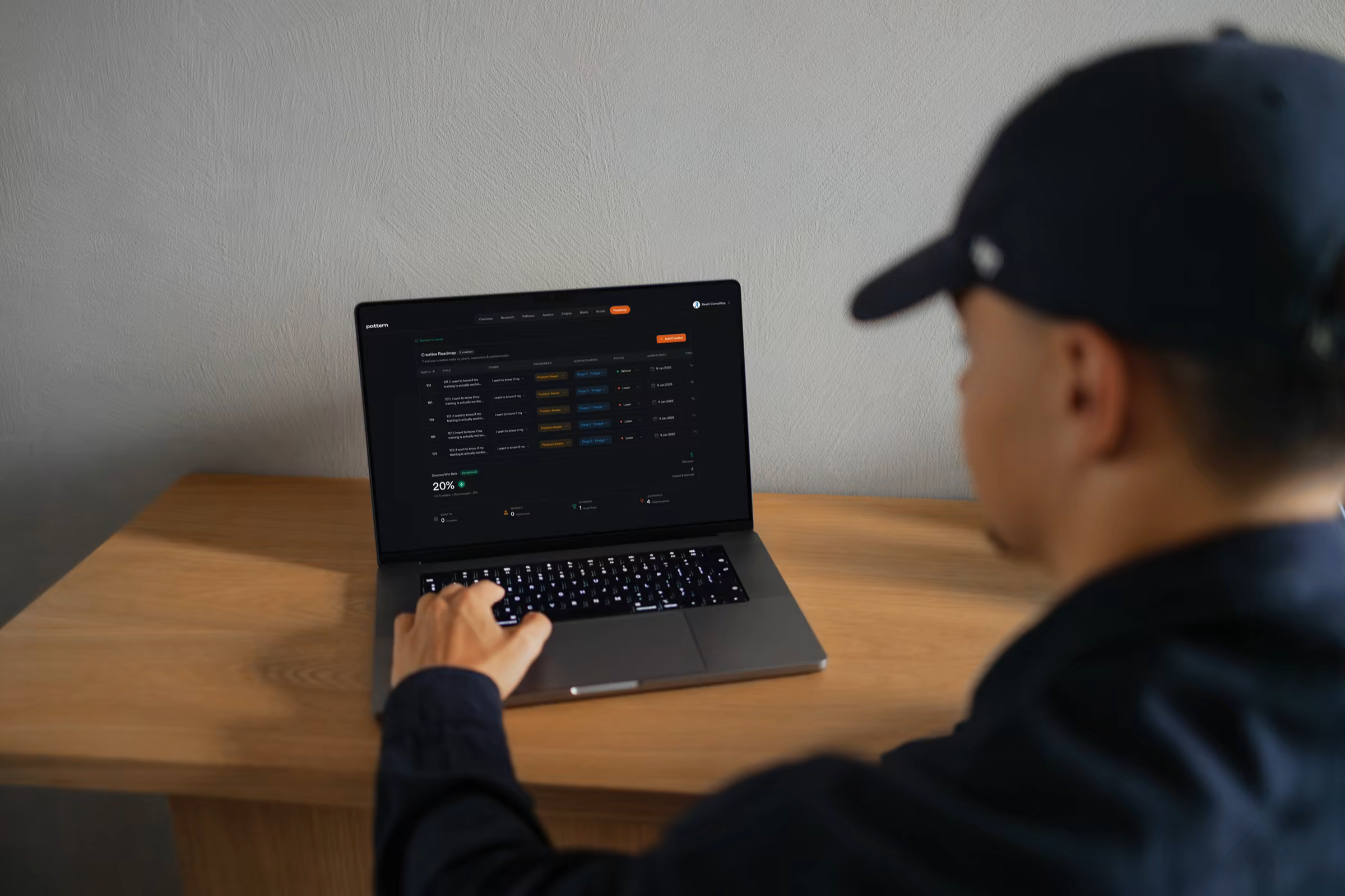 Pattern's Creative Roadmap shown on a MacBook — numbered batches with hypothesis, status, and win-rate.